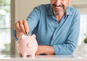 Man putting money in a piggy bank