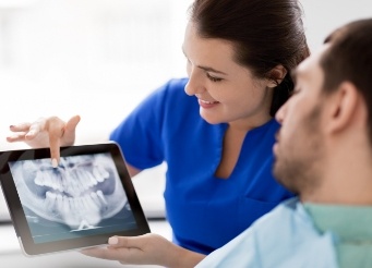 Dental team member and patient looking at x-rays