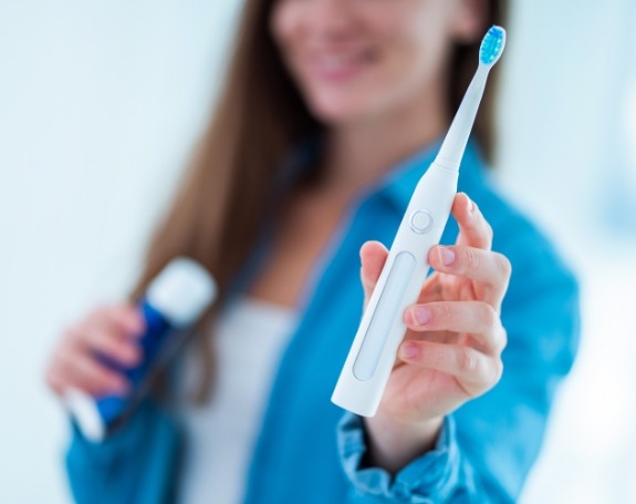 Woman holding up a toothbrush